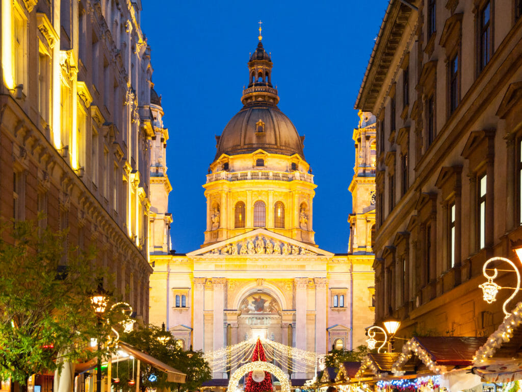 Christmas time in Budapest. Illuminated dome of Saint Stephen's Basilica with holiday street decoration by night