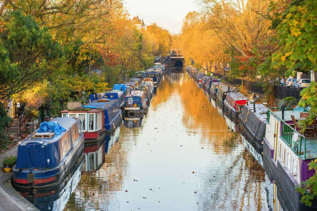 Rows of houseboats and narrow boats on the canal banks at Little Venice, Paddington, West London, on a brigh fall day