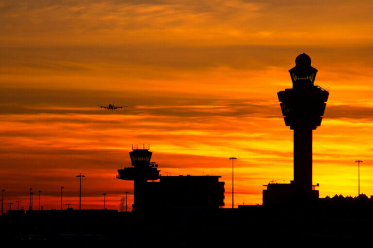 Plane arriving at Amsterdam-Schiphol airport during sunset