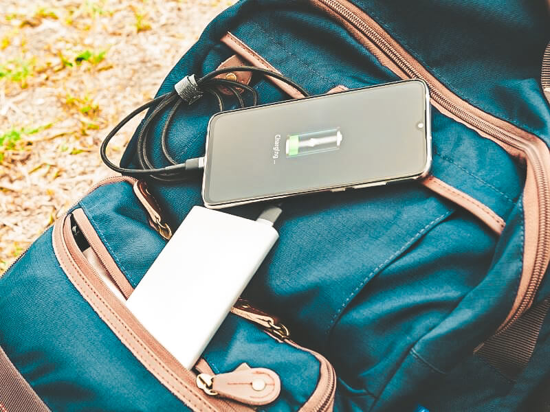 Portable battery bank charging phone whilst hiking