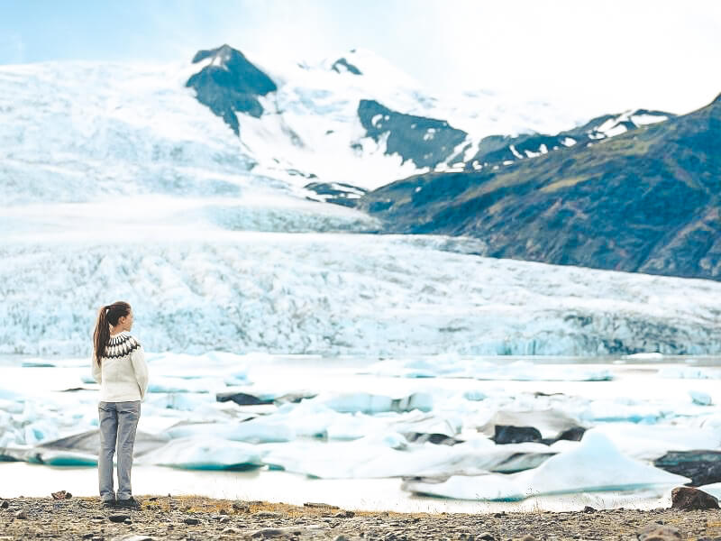 Woman stood next to glacier in Iceland