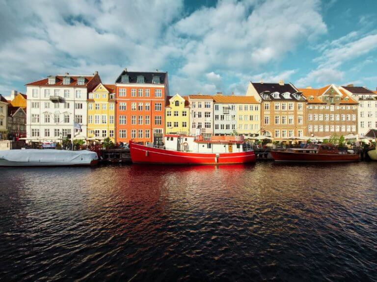 canal in denmark with red and white boat